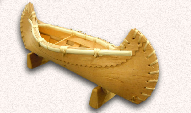Assorted birch bark canoes, baskets, and bowls.