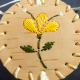 Top lid of round birch bark basket with 3 yellow pedal quill design
